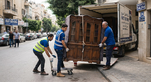 سائقين وعمال نقل ينزلون خزانة أثاث خشبية بعناية